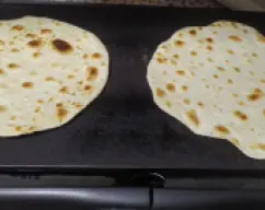 Step <p>Podemos pesar porciones iguales de masa, por ejemplo 100 gramos, estirar bastante bien con el rodillo y cocinar en sartén o plancha de asar, sin aceite, muy caliente, hasta que veamos que ya están</p> illustration