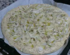 Step <p>Ponemos un papel de hornear sobre la bandeja del horno y extendemos la masa hasta formar un círculo de Ø 35 cm aprox. Poner encima las rodajas de cebolla, espolvoreamos con sal gorda y tomillo y regamos con un poco de AOVE . Aplastar la masa con los dedos para que se integren bien los ingredientes</p> illustration